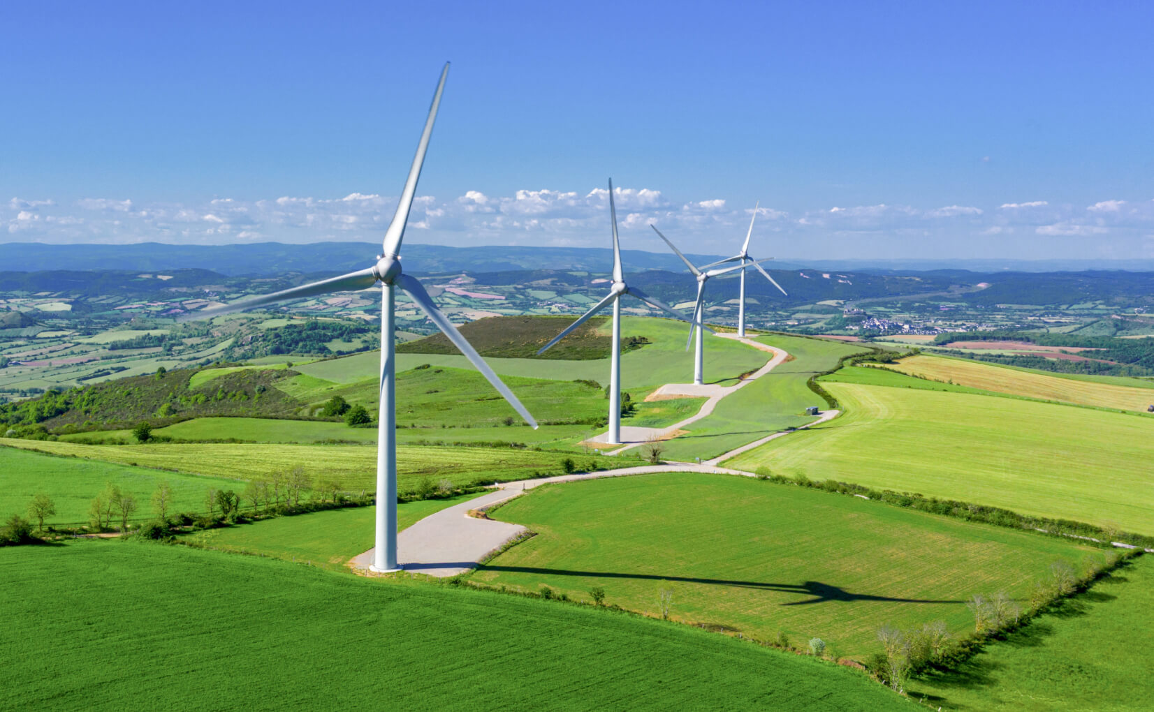 Wind energy windmills in green fields.