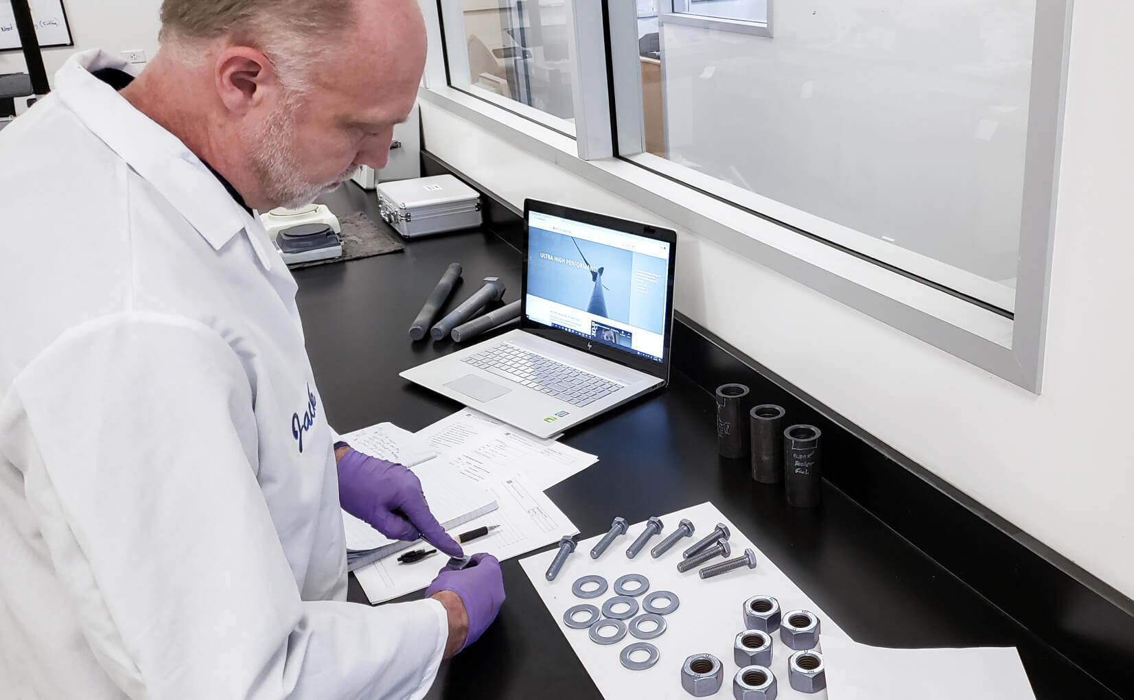 Scientist in lab measuring nanolaminated fasteners.