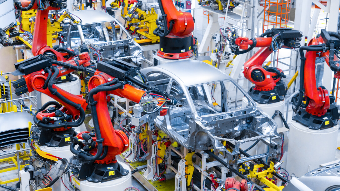 Automotive frame manufacturing line with robotic arms.